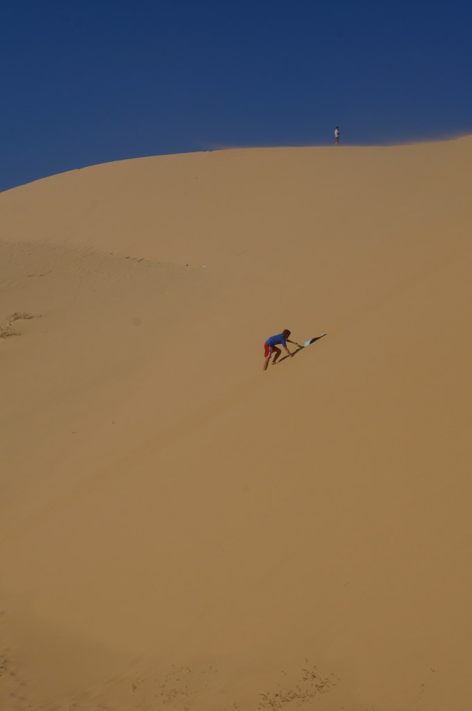 Brian attempting to sand board down the dunes!