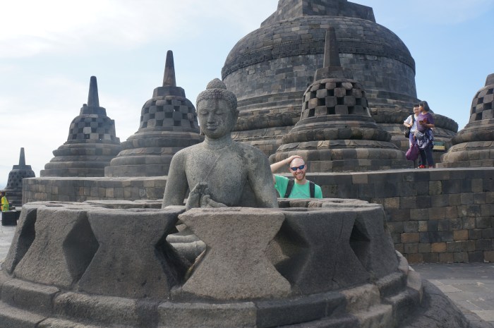 Is that a monk hiding behind that Buddha statue?