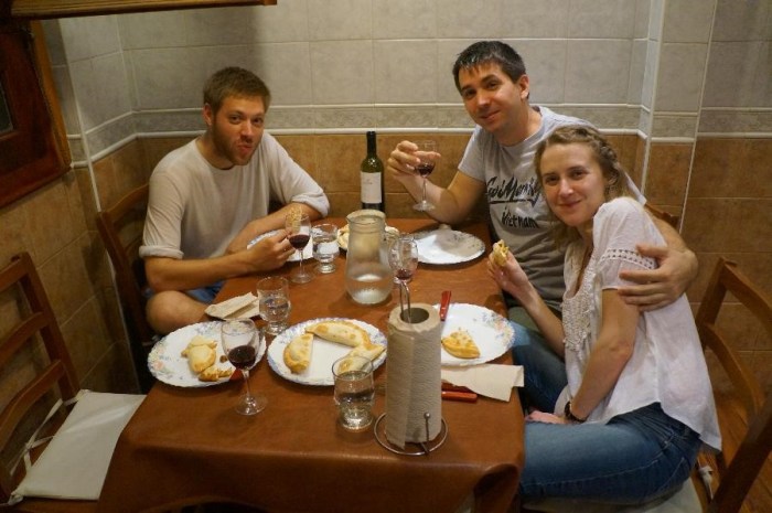 Eating empanadas, fried pastries stuffed with a variety of meat, cheese, and veggies